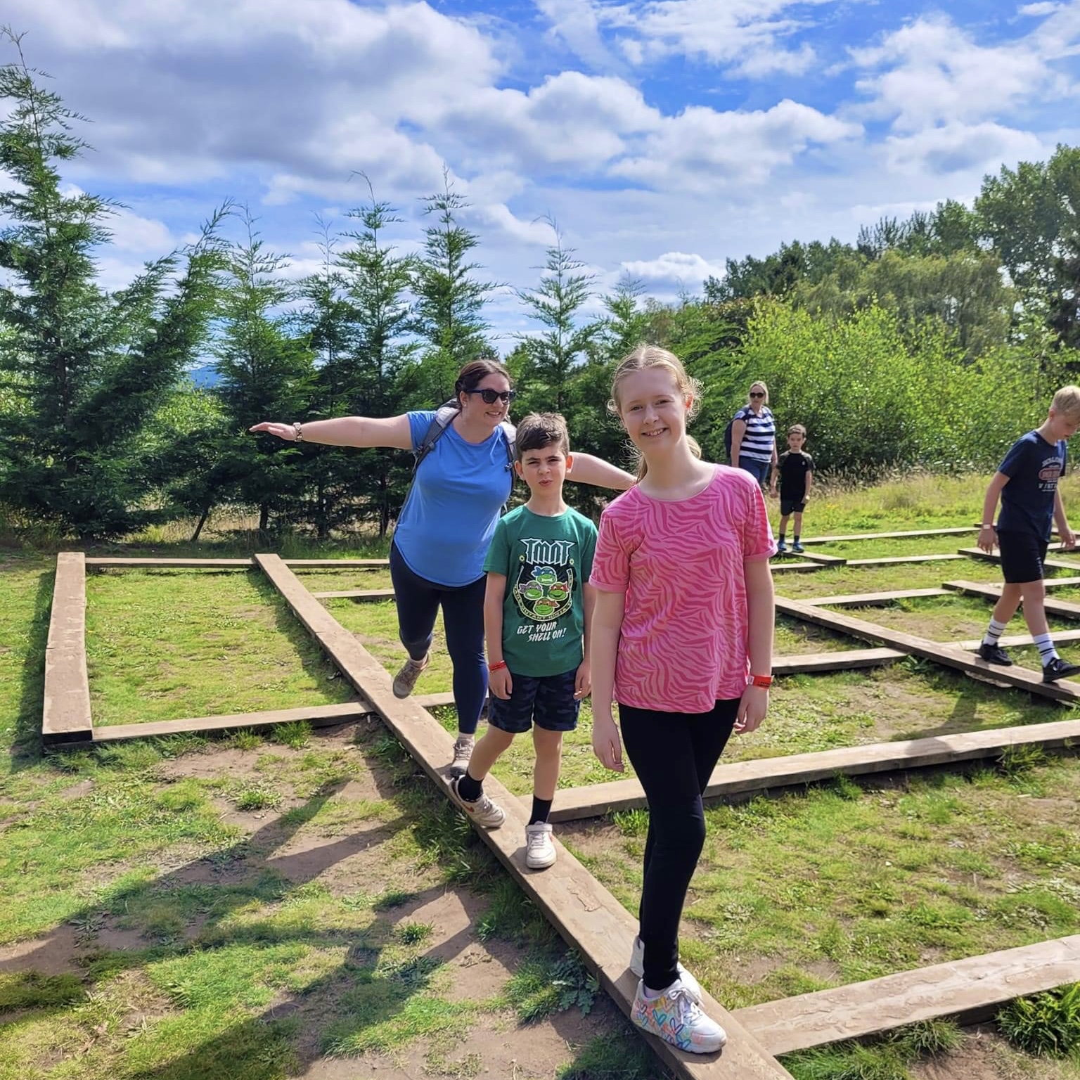 Family enjoying the Crocodile Maze balance beam adventure trail challenge at Habberley Trail in Worcestershire